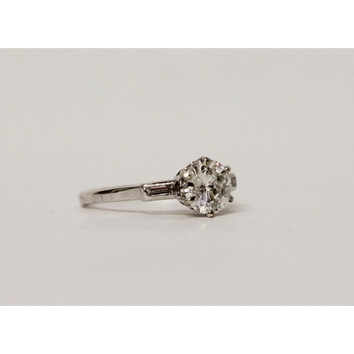 587 - A three stone diamond ring in the Art Deco style, the principal brilliant cut diamond weighing 1.37c... 