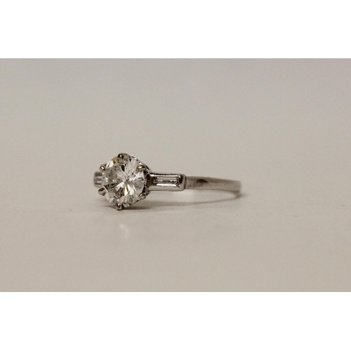 587 - A three stone diamond ring in the Art Deco style, the principal brilliant cut diamond weighing 1.37c... 