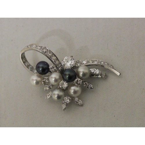 612 - A diamond and cultured pearl spray brooch with a principal claw set brilliant cut diamond weighing a... 