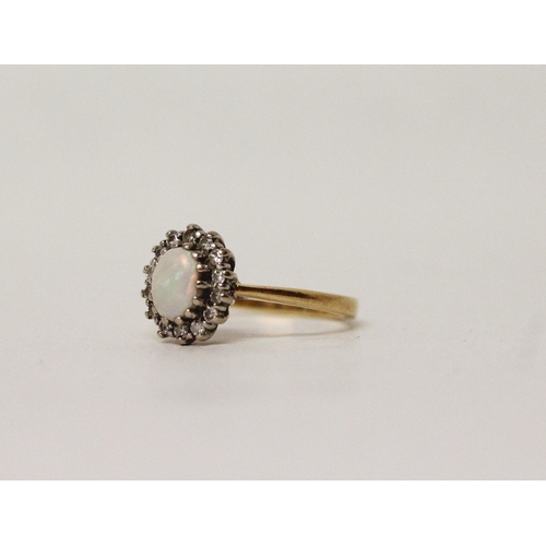 617 - An oval opal and diamond cluster ring on hallmarked 18ct gold band. Ring size K, 3.3 grams