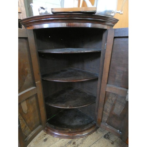 196 - A Georgian oak hanging corner cabinet with decorative brass hinges and escutcheons