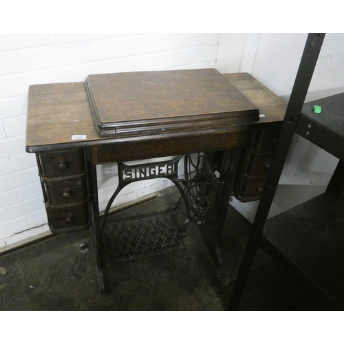 334 - A fold away singer sewing machine in cabinet with six drawers