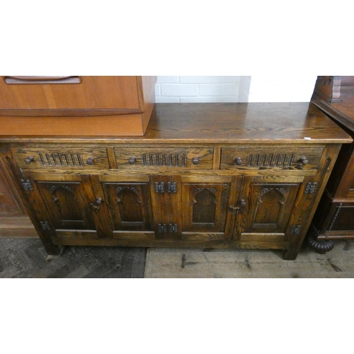 197 - A Titchmarsh and Goodwin style oak sideboard fitted three drawers and and four panel doors, 5' wide