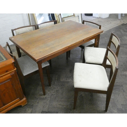 235 - A 1970's Danish teak draw leaf dining table and six similar chairs with cream upholstered seats and ... 