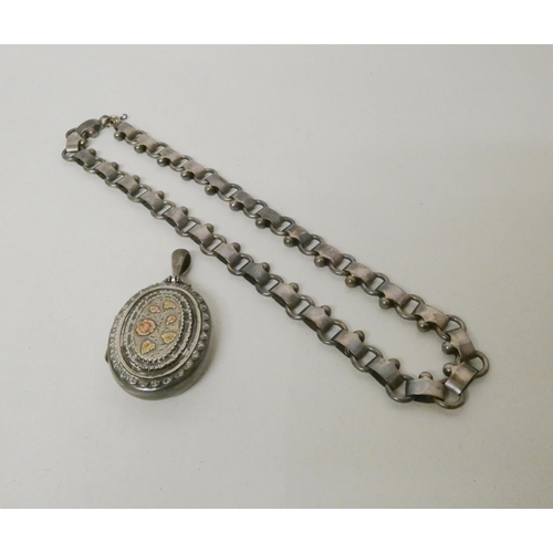 552 - Victorian silver oval locket with gold inlaid floral decoration to the front, hallmarked, with a wid... 