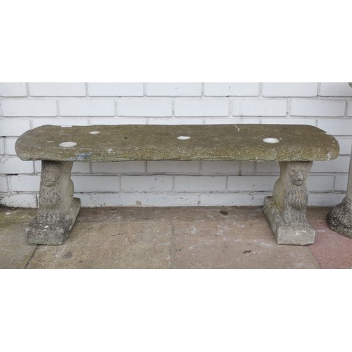 415 - A reconstituted stone three section garden seat with lion faced pedestals