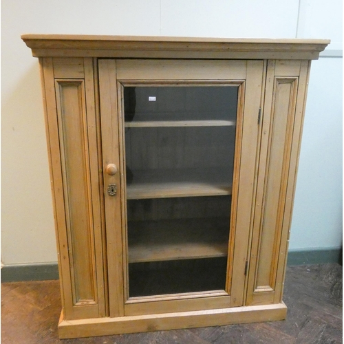 10 - A stripped and waxed pine cabinet with single glass door and interior shelves, 37