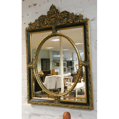 4 - An antique style decorative gilt and black framed wall mirror with oval centre, 34