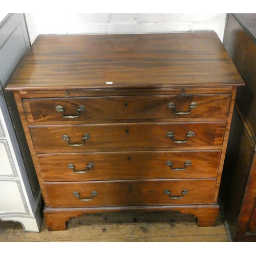 5 - A Georgian mahogany bachelors chest of four long drawers with brushing slide standing on bracket fee... 