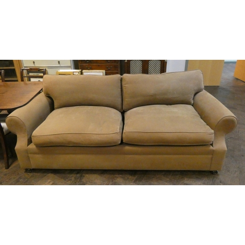 9 - A large two seater sofa with loose cushions in pale brown linen