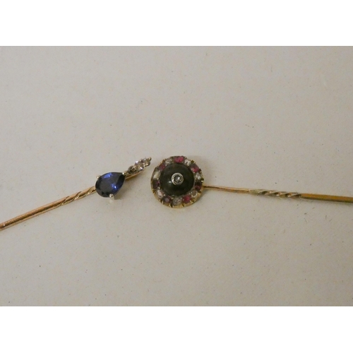 533 - Two stick pins - one circular set with rubies and diamonds, the other a tear drop shaped sapphire wi... 