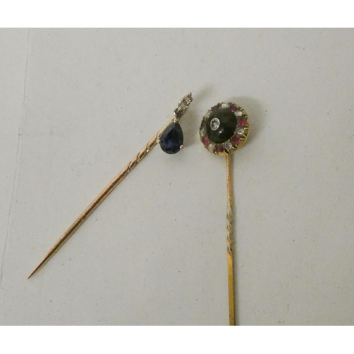 533 - Two stick pins - one circular set with rubies and diamonds, the other a tear drop shaped sapphire wi... 