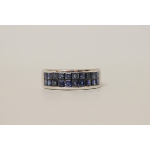 546 - A modern 9ct white gold and blue sapphire band, set with a double row of calibre cut sapphires on ha... 