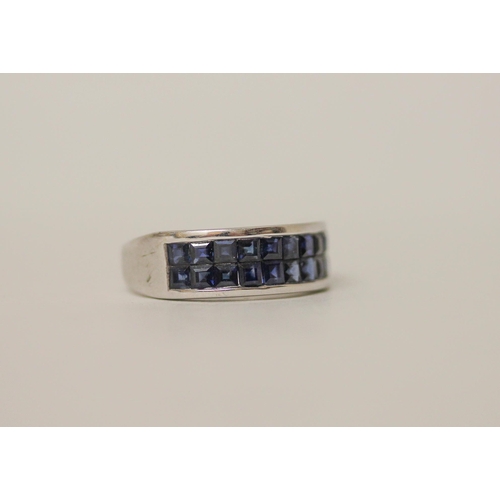 546 - A modern 9ct white gold and blue sapphire band, set with a double row of calibre cut sapphires on ha... 