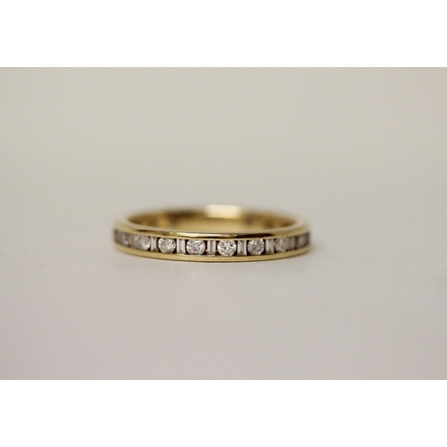 549 - A modern full diamond eternity ring, set with alternate calibre cut and baton diamonds. 18ct hallmar... 