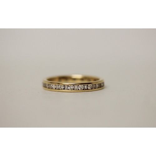 549 - A modern full diamond eternity ring, set with alternate calibre cut and baton diamonds. 18ct hallmar... 