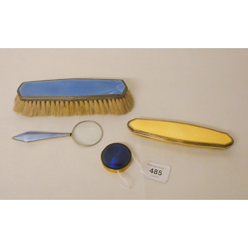 485 - A collection of silver and enamel pieces - nail buffer, magnifying glass and clothes brush, together... 