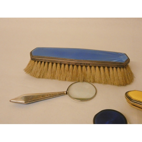 485 - A collection of silver and enamel pieces - nail buffer, magnifying glass and clothes brush, together... 