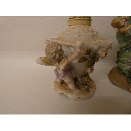 88 - Two Continental porcelain cherub and floral decorated lamp bases, tallest one measuring 31cm
