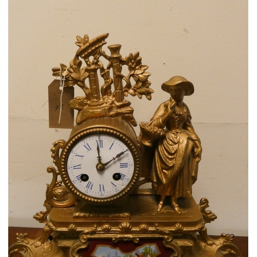 11 - A French striking gilt figure mounted mantel clock with a porcelain panel