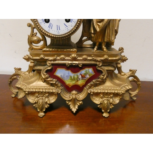 11 - A French striking gilt figure mounted mantel clock with a porcelain panel