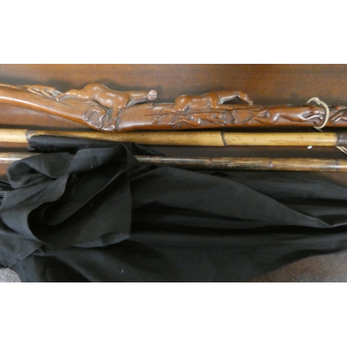 19 - A collection of sticks to include a carved wood walking stick, a silver mounted stick, a bamboo and ... 