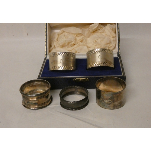 402 - A collection of silver napkin rings, to include a cased pair. Silver weight 4.8 troy ounces