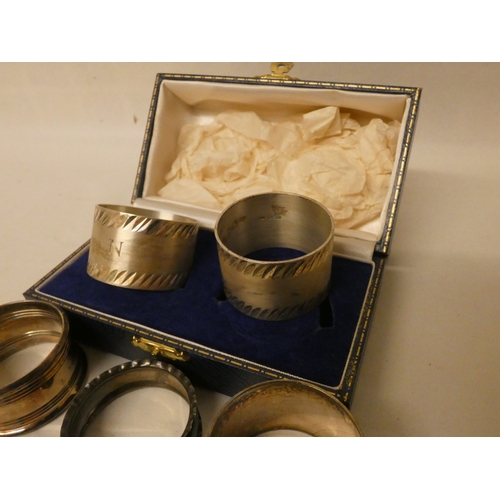 402 - A collection of silver napkin rings, to include a cased pair. Silver weight 4.8 troy ounces