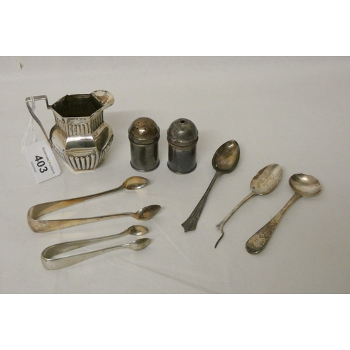 403 - A silver cream jug, two pairs of silver sugar nips, salt & pepper pots and three silver spoons. Weig... 