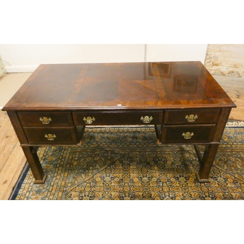 116 - A Georgian style mahogany writing desk with cross banded top fitted with five drawers with brass han... 