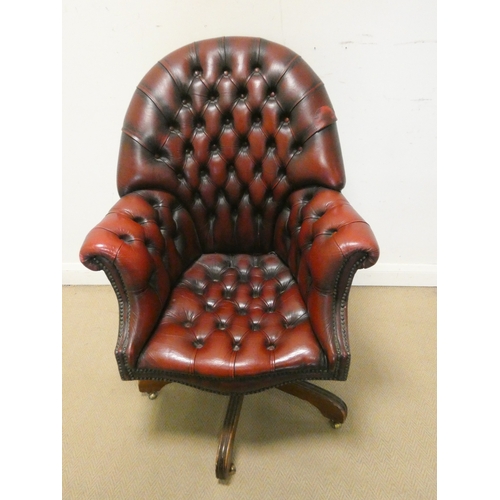 117 - A red buttoned leather revolving office elbow chair