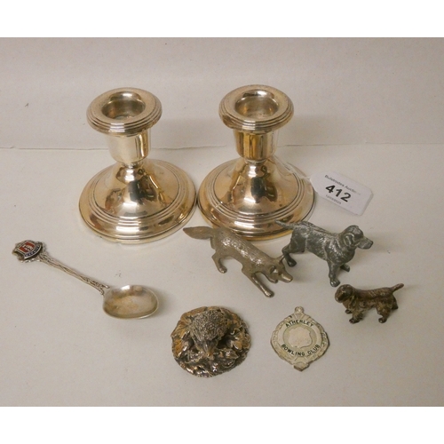 412 - A pair of silver dwarf candlesticks, silver covered hedgehog, silver spoon, and silver plated animal... 