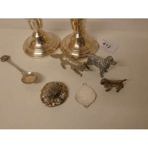 412 - A pair of silver dwarf candlesticks, silver covered hedgehog, silver spoon, and silver plated animal... 