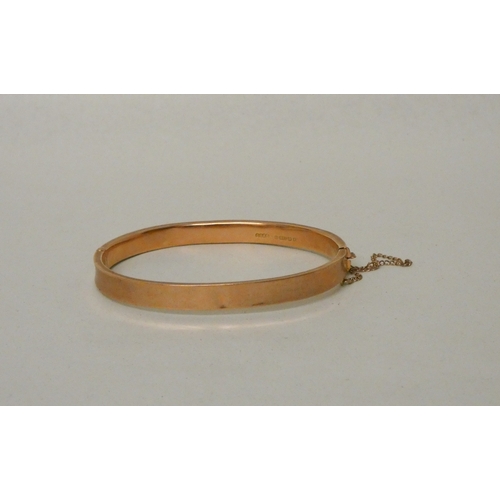 421 - 9ct rose gold hinged bangle, with invisible box clasp and safety chain fitted. Gross weight 7.7g