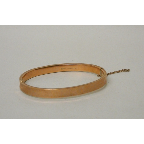 421 - 9ct rose gold hinged bangle, with invisible box clasp and safety chain fitted. Gross weight 7.7g