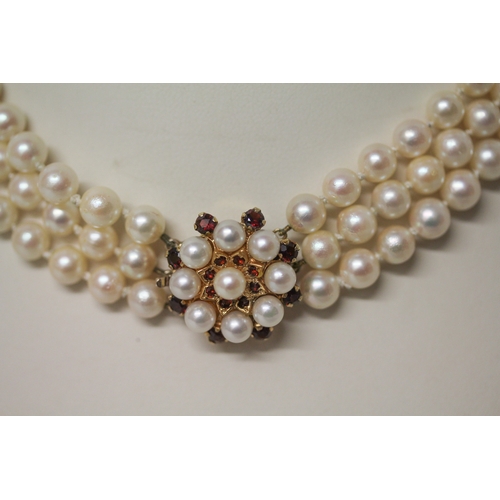 423 - A Triple Row Cultured Pearl Choker, with A Cultured Pearl and garnet Cluster Clasp, hallmarked 9ct g... 