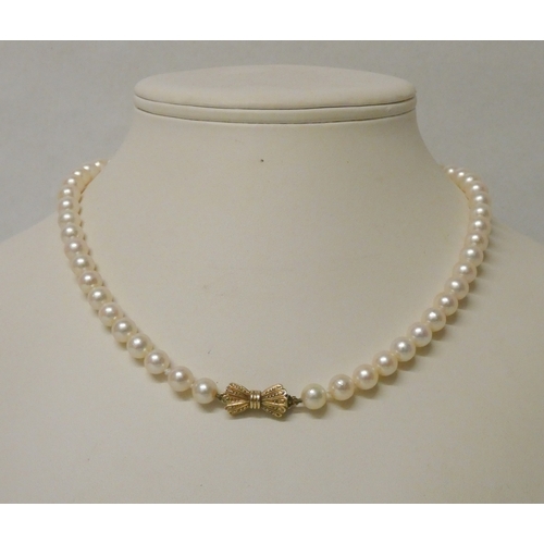 424 - A uniform row of cultured pearls to a 9ct hallmarked ribbon bow clasp. 6mm pearls. 43cms long