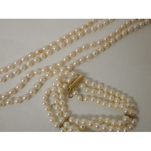 425 - A triple row cultured pearl bracelet with 9ct gold spacers and a 9ct and pearl set clasp, with a lon... 