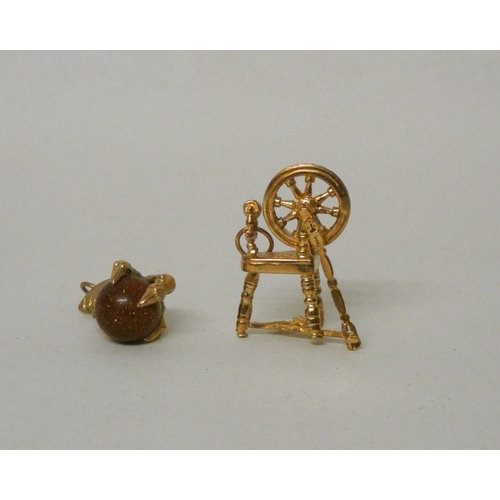 430 - A 9ct gold spinning wheel charm and a bloodstone eagles claw charm, marked 9ct. Gross weight 10g