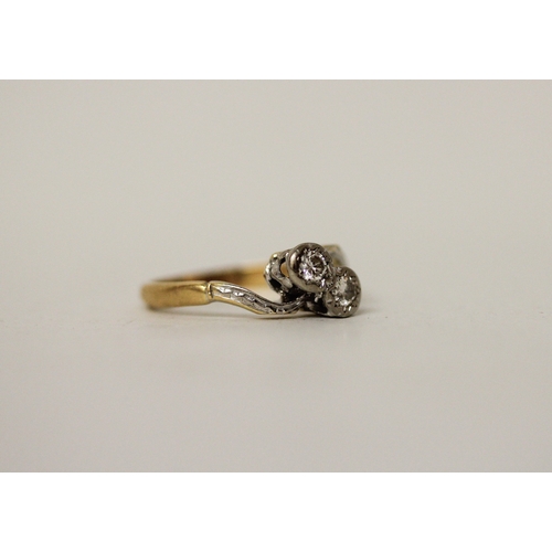 433 - A vintage 18ct & platinum mounted two stone diamond ring, set in a cross over design. Band marked 18... 