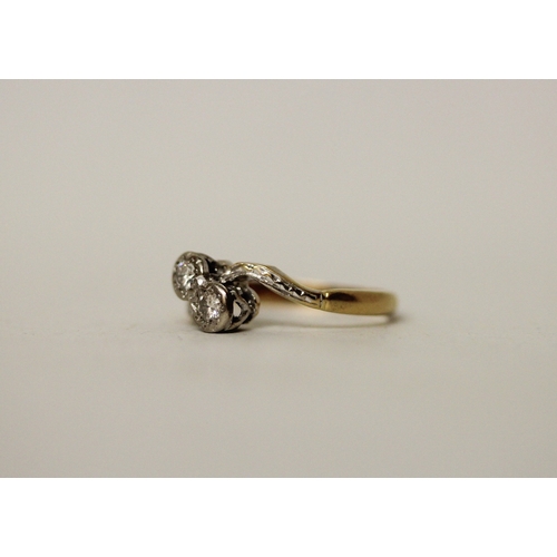 433 - A vintage 18ct & platinum mounted two stone diamond ring, set in a cross over design. Band marked 18... 