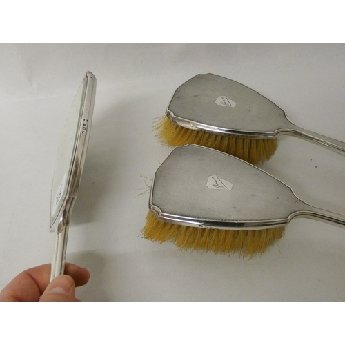 435 - A three piece silver backed hairbrush set, engine turned backs engraved Joan.