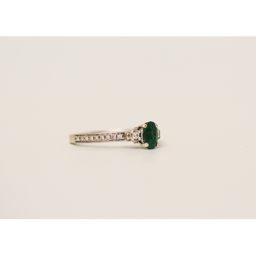 452 - An emerald and diamond ring on hallmarked 18ct white gold band, ring size K,