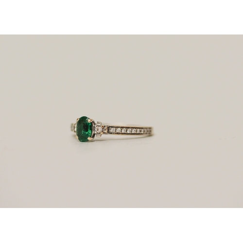 452 - An emerald and diamond ring on hallmarked 18ct white gold band, ring size K,