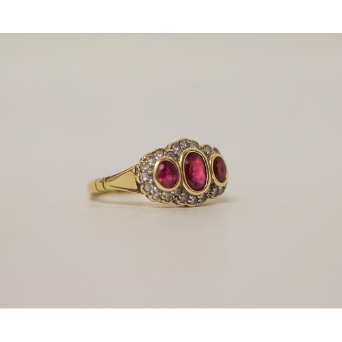 458 - A ruby and diamond three stone cluster ring on an 18ct yellow gold band, ring size M, 4.2 grams