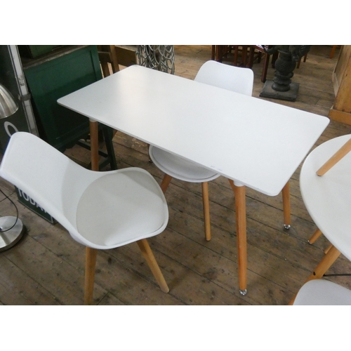 A modern white kitchen table and two similar dining chairs