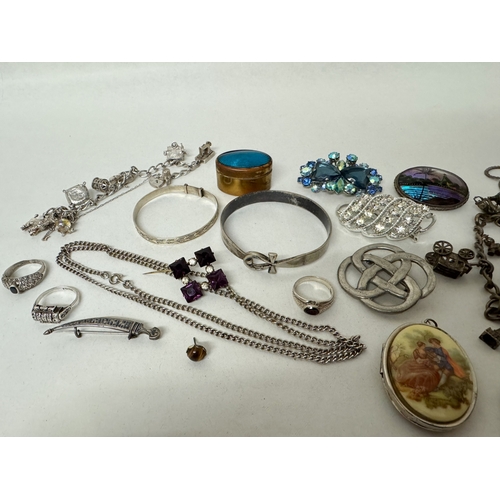 413 - Two silver charm bracelets, two silver bangles, silver and marcasite deco ring, vintage butterfly wi... 