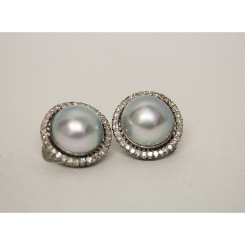 423 - A pair of grey mabe pearl and diamond ear clips, in a large circular cluster on 14k white gold clip ... 