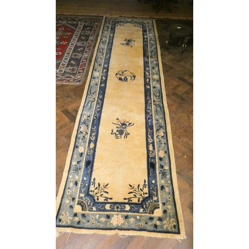 A long fawn and blue patterned Chinese carpet runner, approx. 12' x 3'