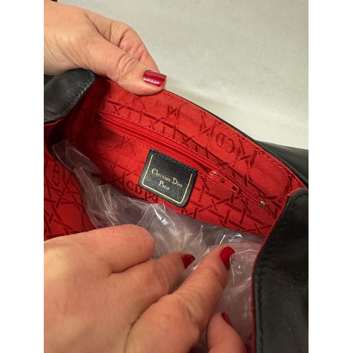 541 - A black leather handbag with Dior labels and a red quilted gloss clutch bag in Dior box